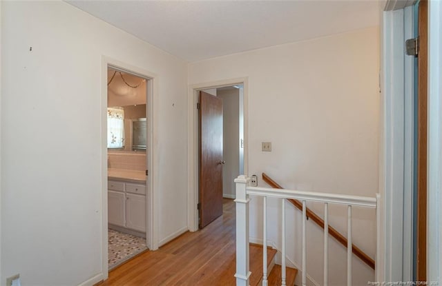 hallway featuring light wood finished floors and an upstairs landing