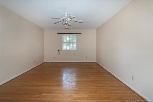 spare room with light wood-style floors, baseboards, and ceiling fan