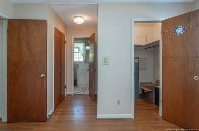 corridor with baseboards and wood finished floors