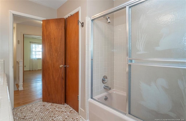bathroom with combined bath / shower with glass door
