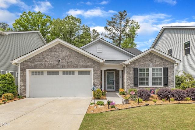 view of front facade with stone siding, an attached garage, concrete driveway, and a front yard