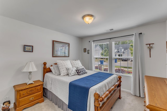 bedroom with light colored carpet and baseboards