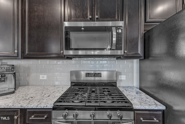 kitchen with stainless steel appliances, dark brown cabinetry, and decorative backsplash