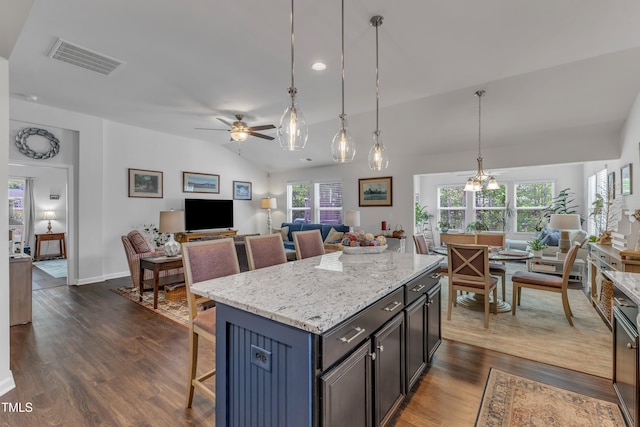 kitchen with open floor plan, vaulted ceiling, dark wood-type flooring, ceiling fan, and healthy amount of natural light