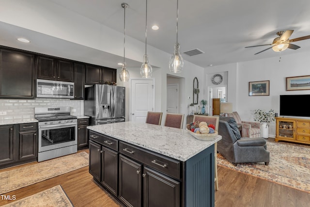 kitchen featuring appliances with stainless steel finishes, open floor plan, light wood-type flooring, ceiling fan, and recessed lighting