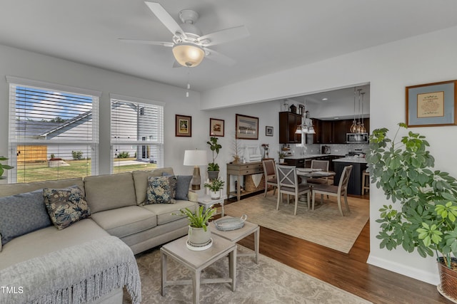 living room with wood finished floors, ceiling fan, and baseboards