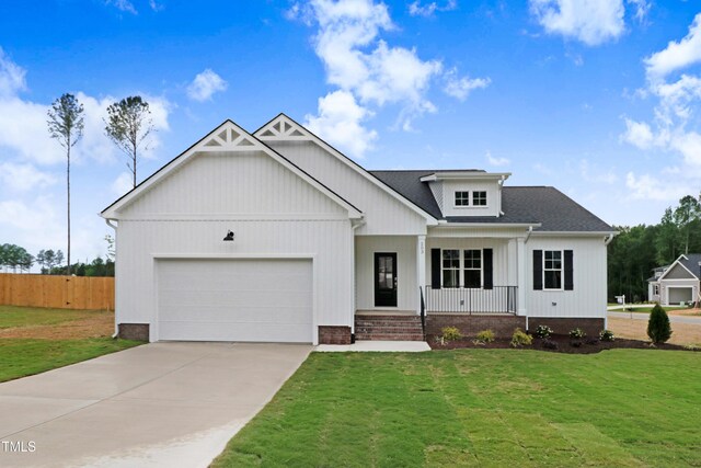 203 Sourgum Ct, Zebulon, NC 27597 - view of front of property with a porch, a garage, driveway, and a shingled roof