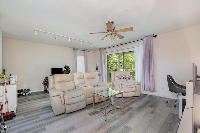 living room featuring a ceiling fan, a textured ceiling, and wood finished floors
