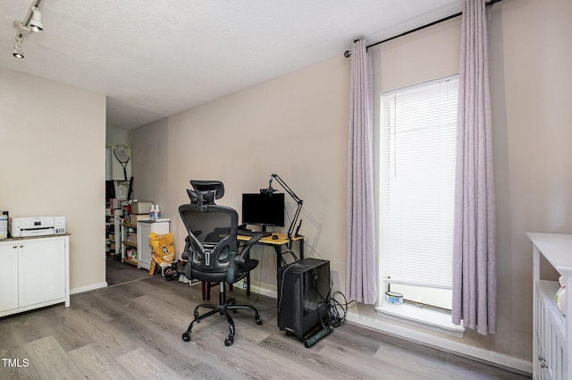 office area with baseboards, rail lighting, and wood finished floors