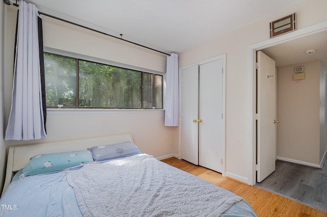bedroom featuring baseboards, a closet, and wood finished floors