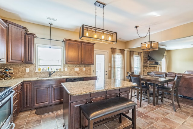kitchen with decorative light fixtures, tasteful backsplash, visible vents, and stainless steel electric range oven