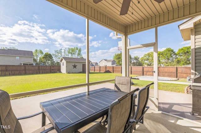 sunroom / solarium with outdoor dining area and a ceiling fan