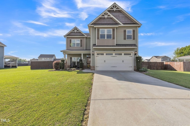 craftsman-style house with fence, concrete driveway, an attached garage, board and batten siding, and a front yard