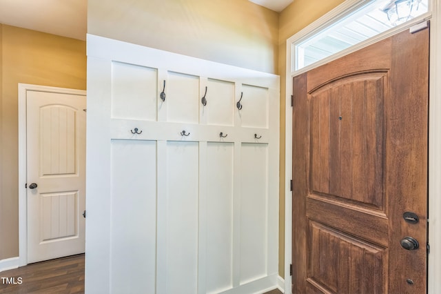 mudroom featuring dark wood finished floors and baseboards