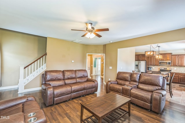 living area with a ceiling fan, visible vents, and dark wood-style floors