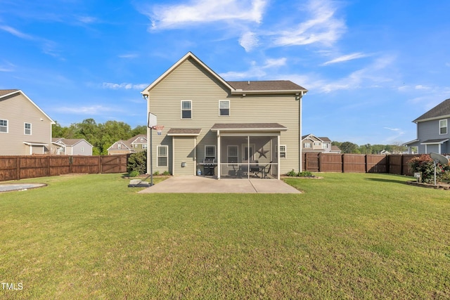 rear view of house with a yard, a patio area, a sunroom, and a fenced backyard