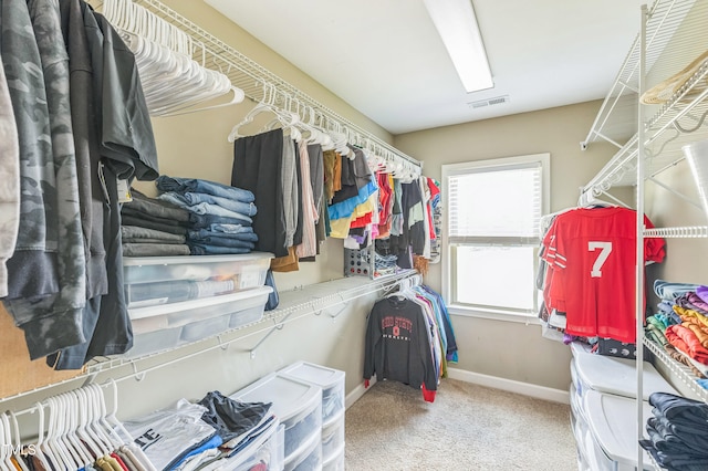 walk in closet with visible vents and carpet