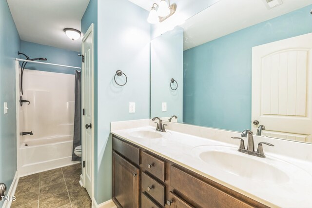 full bathroom with  shower combination, a sink, double vanity, and toilet