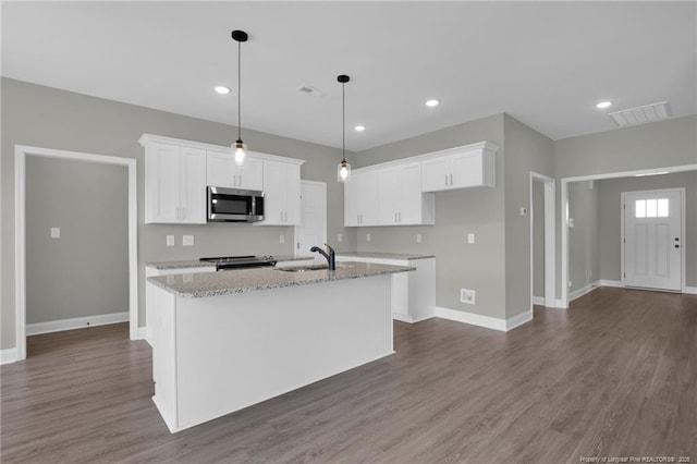 5566 Philippi Church Rd, Raeford, NC 28376 - kitchen with stainless steel appliances, a kitchen island with sink, white cabinets, dark wood finished floors, and recessed lighting