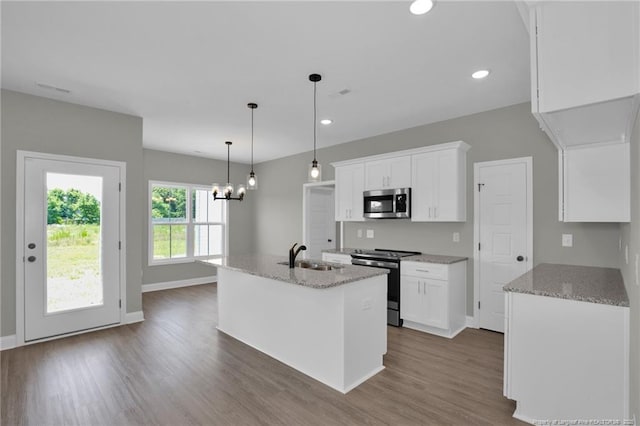 5566 Philippi Church Rd, Raeford, NC 28376 - kitchen with electric range oven, stainless steel microwave, a sink, wood finished floors, and white cabinets