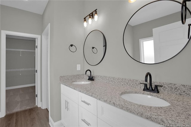 5566 Philippi Church Rd, Raeford, NC 28376 - bathroom featuring double vanity, wood finished floors, a spacious closet, and baseboards