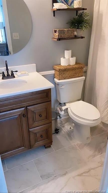bathroom featuring marble finish floor, toilet, and vanity