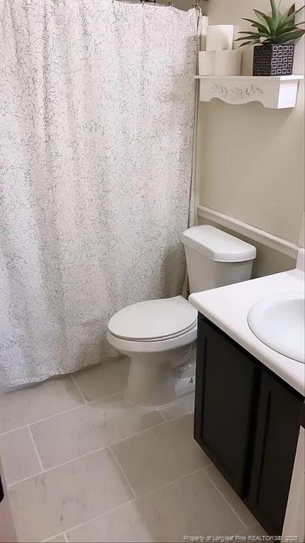 full bathroom with tile patterned flooring, vanity, curtained shower, and toilet