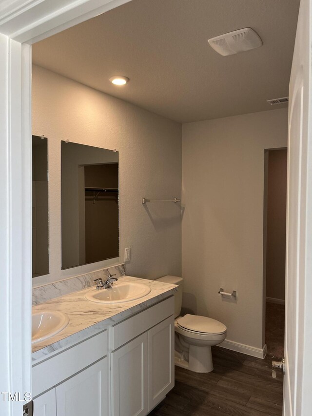 209 Lillian Ct, Roxboro, NC 27573 - full bathroom with a sink, double vanity, toilet, visible vents, and wood finished floors