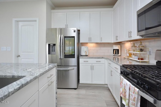490 Mallard Loop Dr, Clayton, NC 27527 - kitchen with white cabinets, backsplash, light stone countertops, and stainless steel appliances