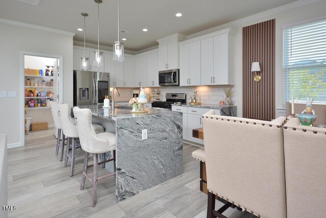 490 Mallard Loop Dr, Clayton, NC 27527 - kitchen with a kitchen bar, appliances with stainless steel finishes, crown molding, and a sink