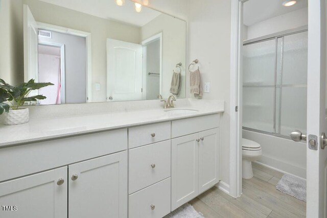 490 Mallard Loop Dr, Clayton, NC 27527 - full bathroom featuring toilet, visible vents, wood finished floors, combined bath / shower with glass door, and vanity