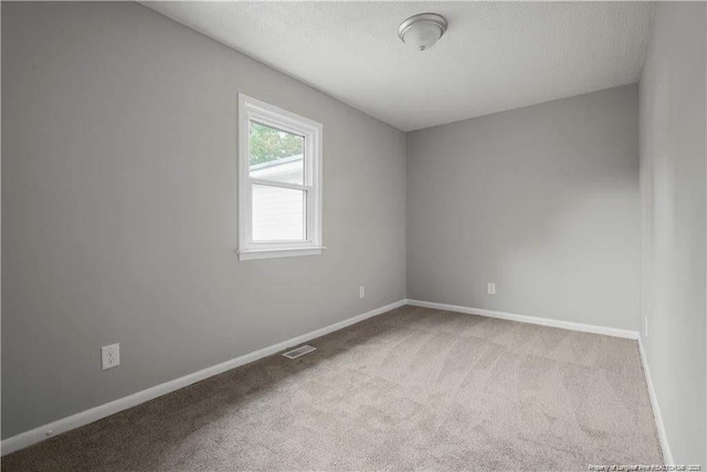 413 Lincoln Mckay Dr, Lillington, NC 27546 - empty room featuring baseboards, carpet flooring, a textured ceiling, and visible vents
