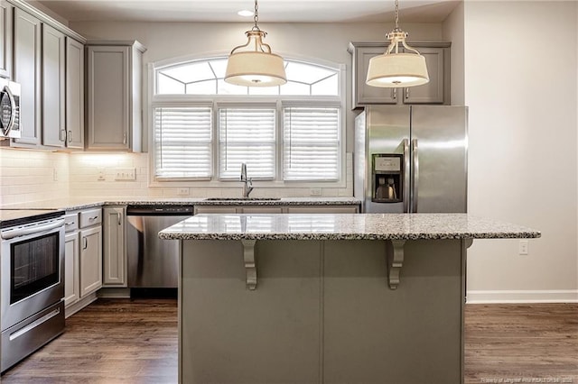 234 Hugh Shelton Loop, Fayetteville, NC 28301 - kitchen featuring stainless steel appliances, gray cabinetry, a kitchen bar, and light stone countertops