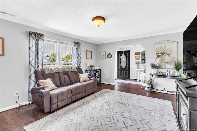 living room with baseboards, visible vents, crown molding, and dark wood-style floors