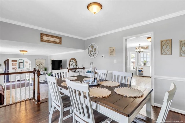 dining area with wood finished floors, a chandelier, and ornamental molding