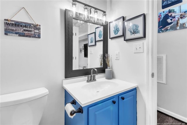 bathroom with visible vents, toilet, and vanity