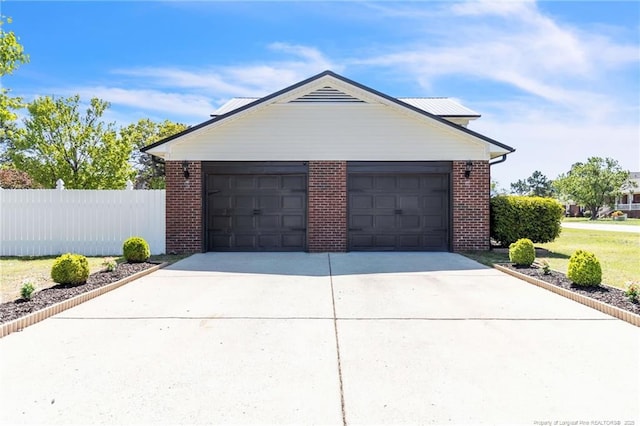 garage with fence and driveway
