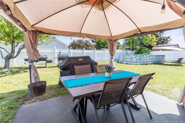 view of patio / terrace with a gazebo, grilling area, outdoor dining space, and fence
