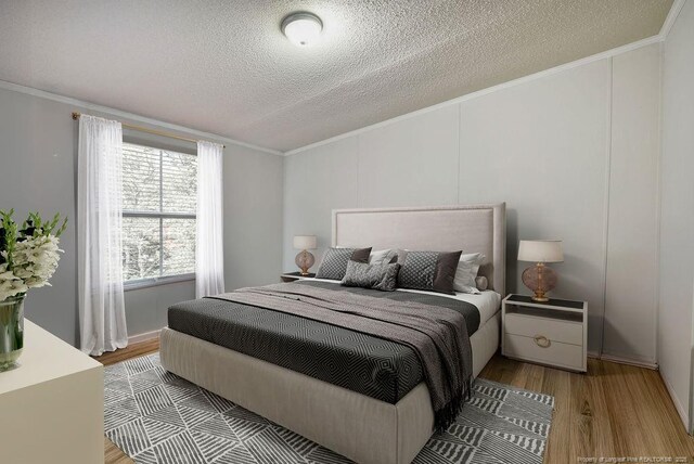 bedroom featuring wood finished floors, a textured ceiling, and ornamental molding