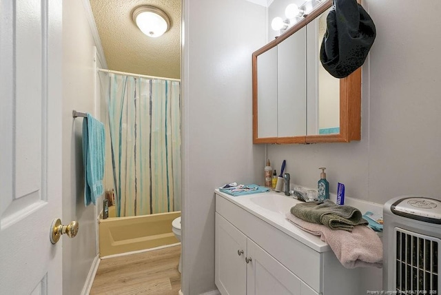 full bath featuring shower / tub combo with curtain, wood finished floors, toilet, and vanity