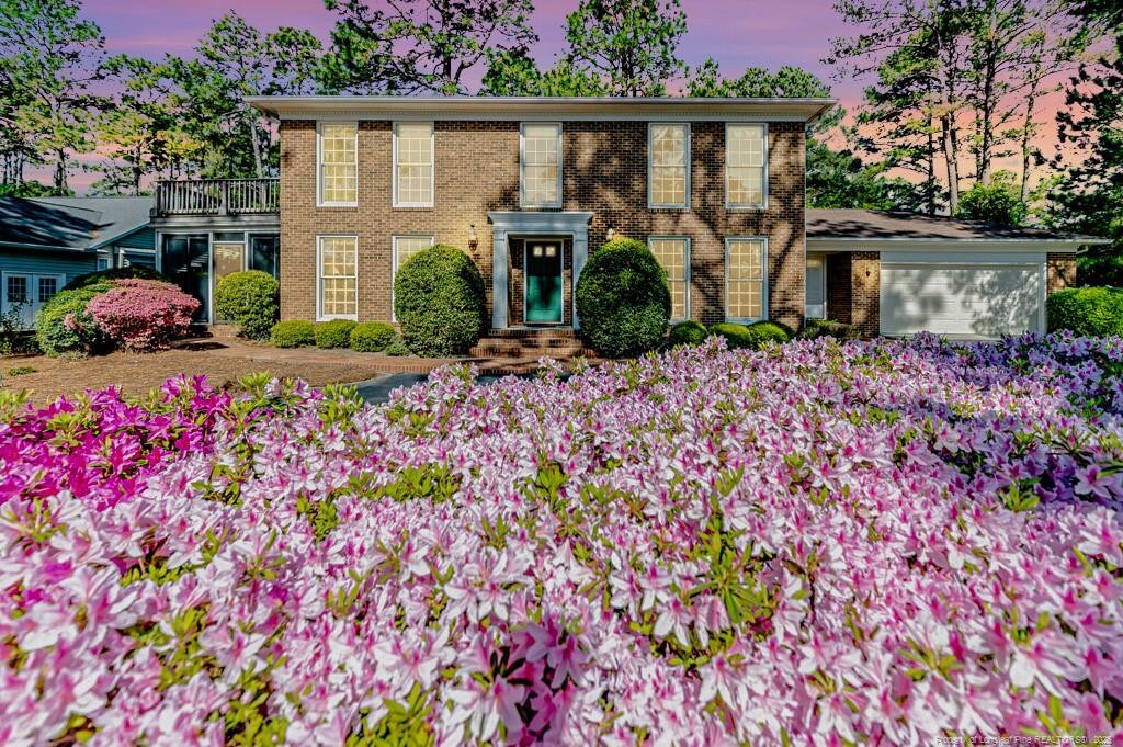 219 Pine Ridge Dr, Whispering Pines, NC 28327 - colonial inspired home with an attached garage and brick siding