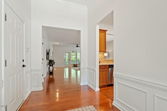 803 Footbridge Pl, Cary, NC 27519 - hallway with a decorative wall, light wood-style floors, a wainscoted wall, and crown molding