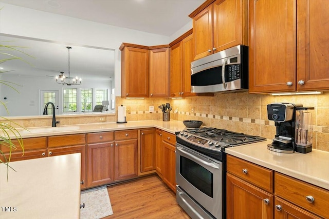803 Footbridge Pl, Cary, NC 27519 - kitchen with brown cabinetry, light countertops, a sink, and appliances with stainless steel finishes
