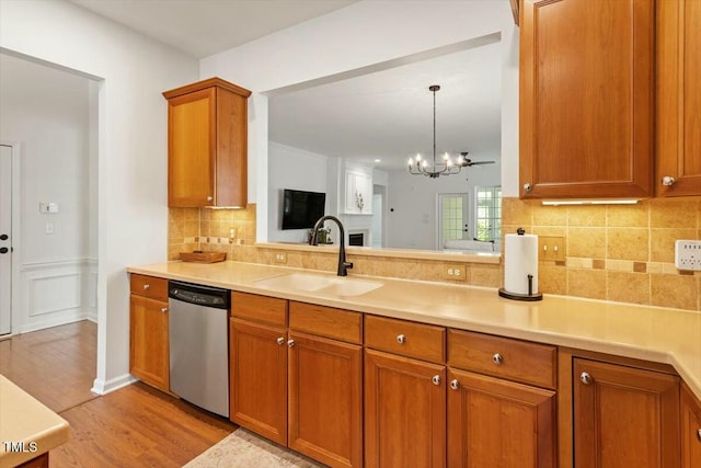 803 Footbridge Pl, Cary, NC 27519 - kitchen with light countertops, a sink, light wood-style floors, brown cabinetry, and dishwasher