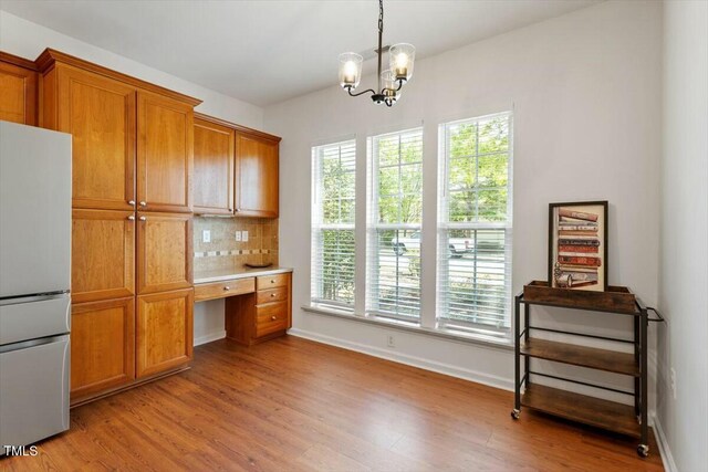 803 Footbridge Pl, Cary, NC 27519 - unfurnished office with a wealth of natural light, a chandelier, and light wood-type flooring