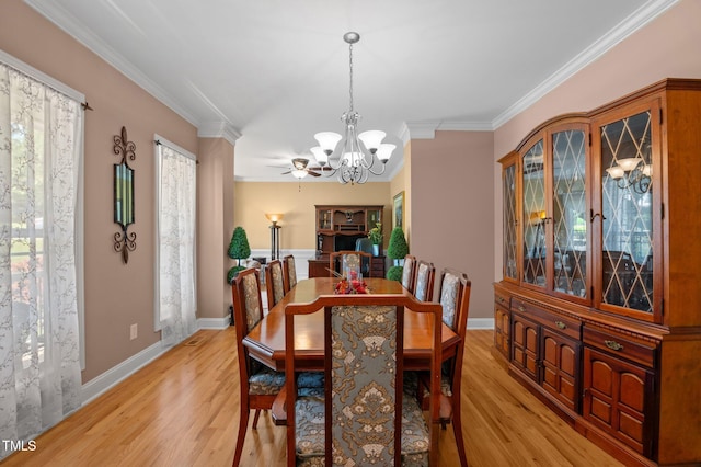 dining room with crown molding, baseboards, and light wood-type flooring