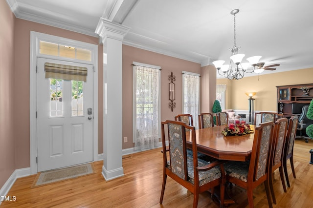 dining room featuring crown molding, decorative columns, a healthy amount of sunlight, and light wood finished floors