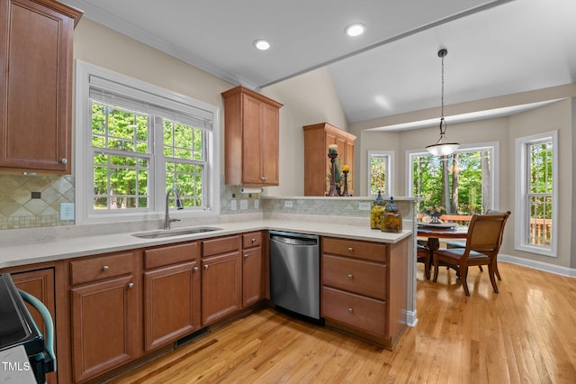 kitchen featuring a sink, light countertops, stainless steel dishwasher, and brown cabinetry