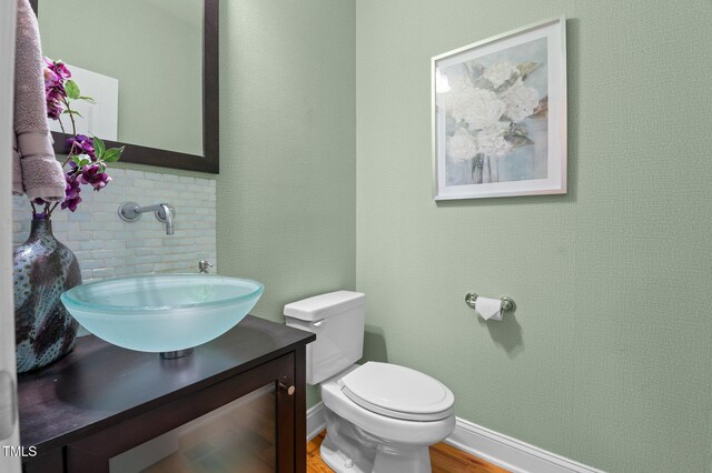 bathroom with vanity, wood finished floors, and toilet