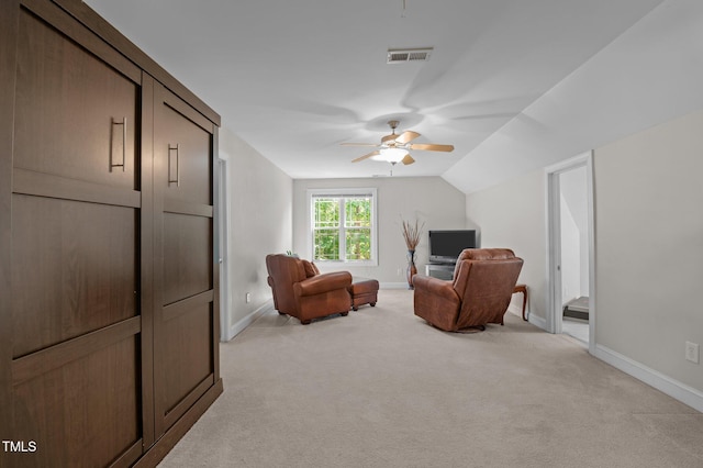 living area with visible vents, light carpet, baseboards, a ceiling fan, and vaulted ceiling